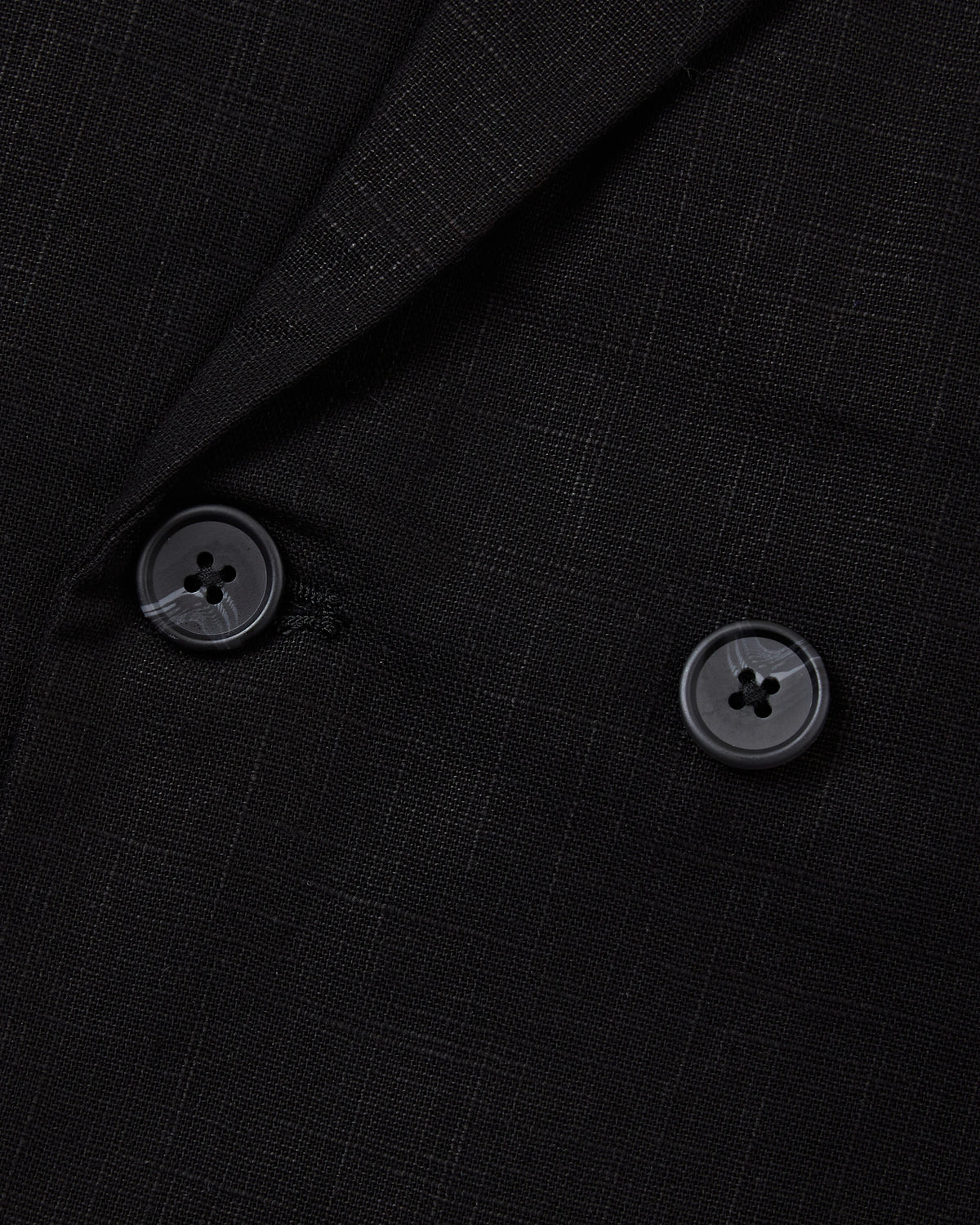 Detail of the double breasted buttons on the black linen blazer