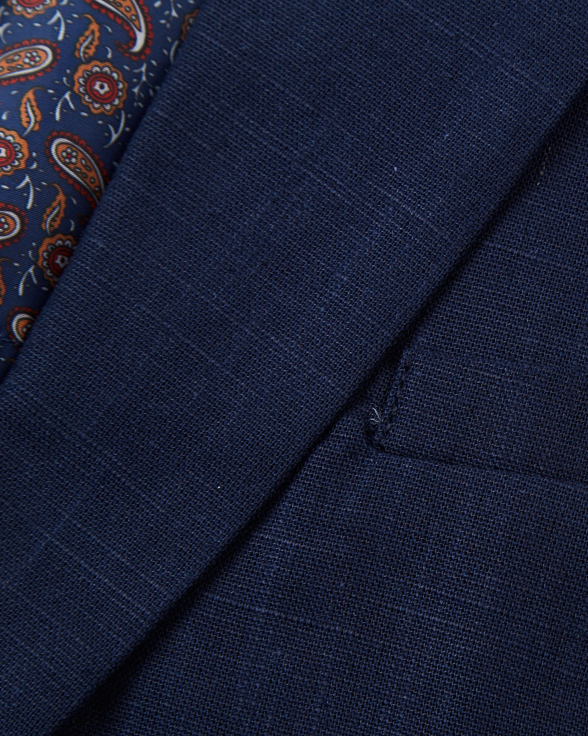 Detail of the paisley lining against the navy linen at the shoulder